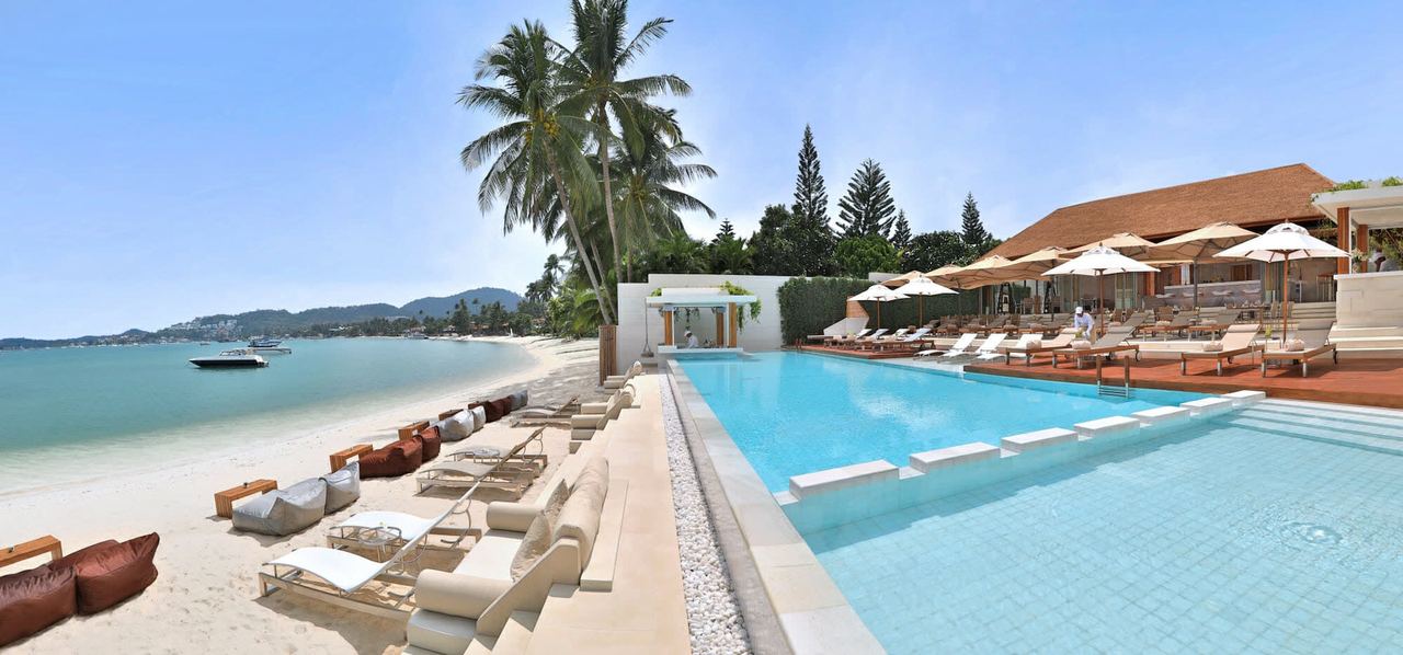 Chi Samui’s infinity pool and white loungers beside the beach at Bang Rak