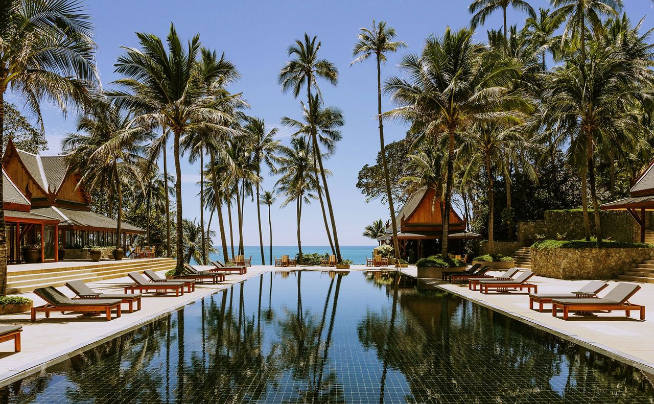 The long black-tiled pool at Amanpuri, framed by palms and Thai pavilions