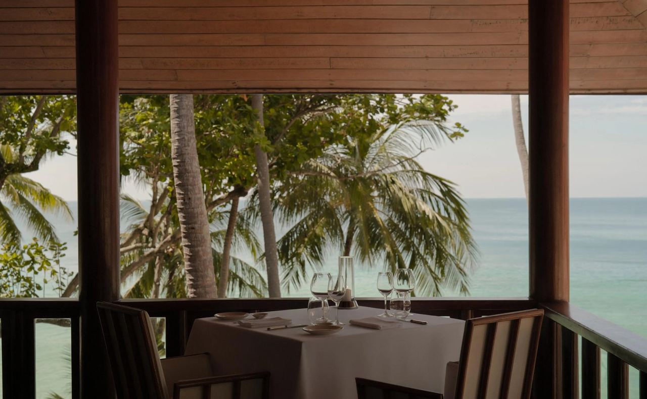 A table laid on an open pavilion above the sea at Amanpuri