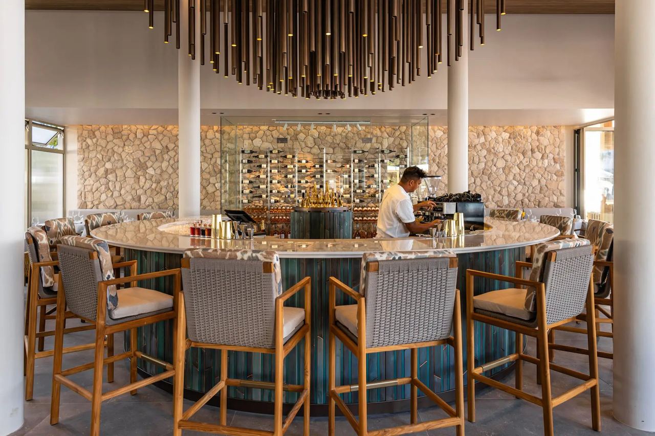 The round bar under a bronze chandelier at Catch Beach Club