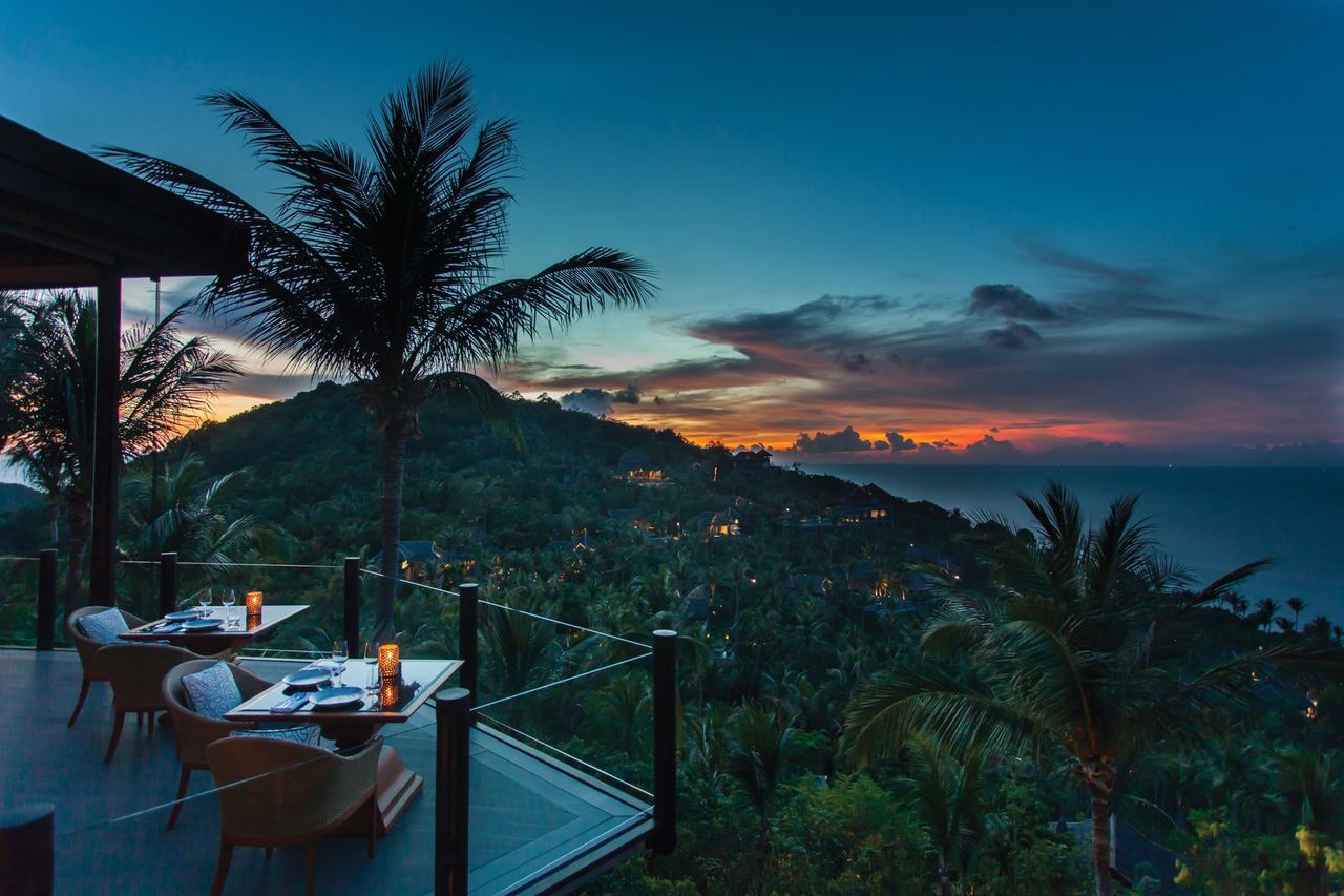 A hillside dining terrace at Four Seasons Resort Koh Samui at dusk