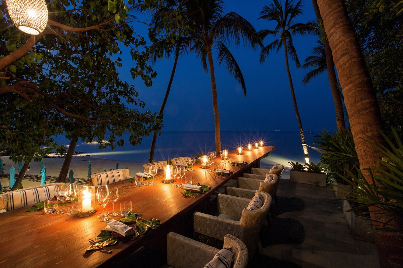 A candlelit table on the beach at Four Seasons Resort Koh Samui
