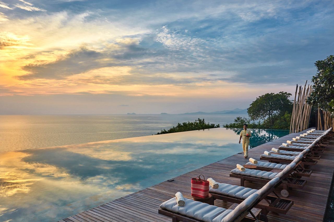 The infinity pool and deck of Six Senses Samui at sunset