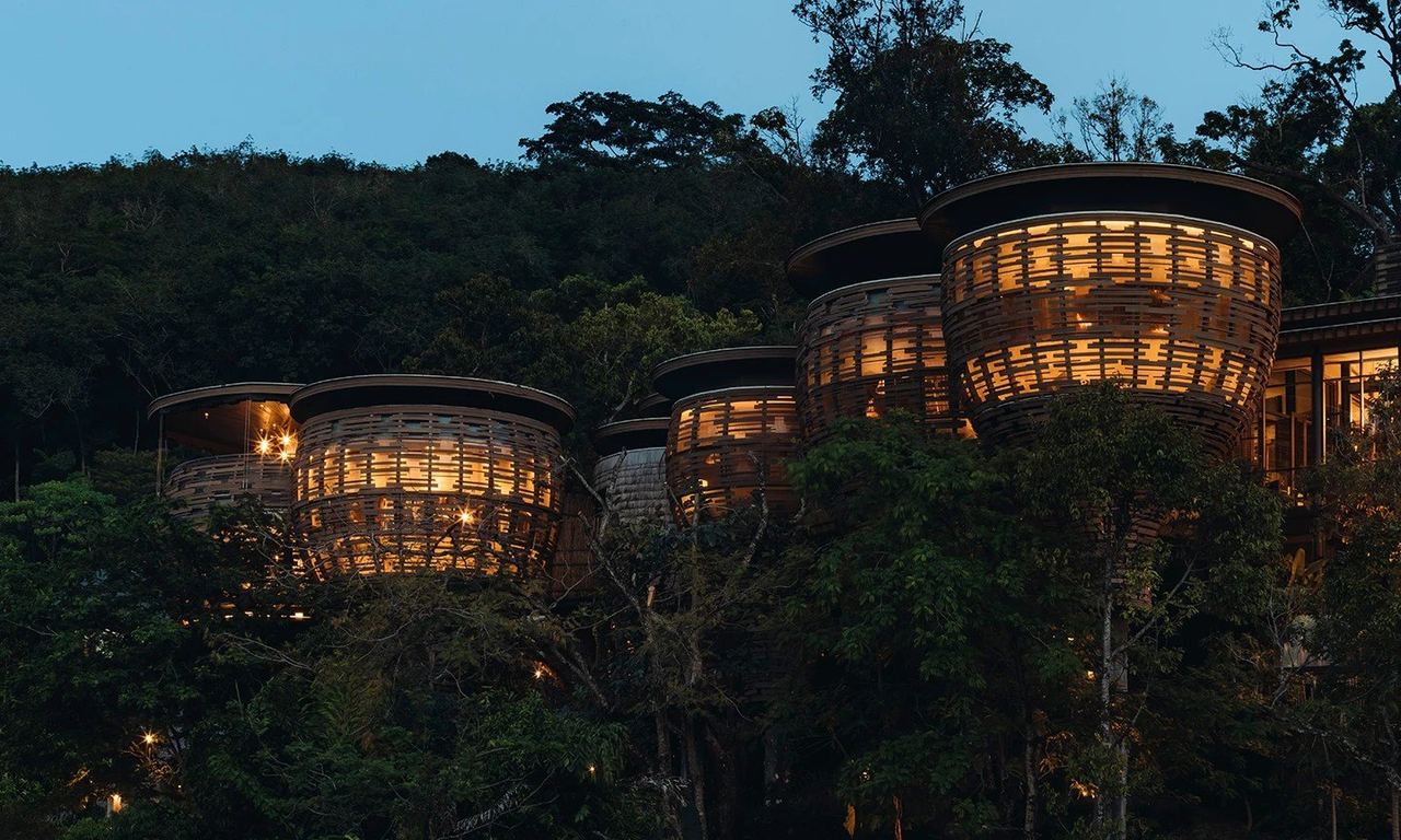 Keemala’s woven villas lit up at dusk among the trees