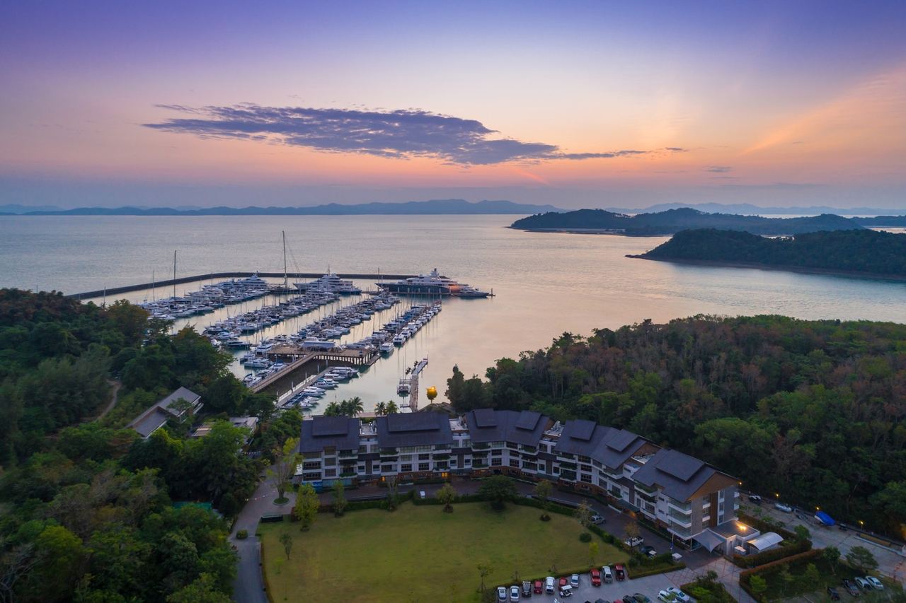 Ao Po Grand Marina from the air at sunset, its pontoons reaching into Phang Nga Bay