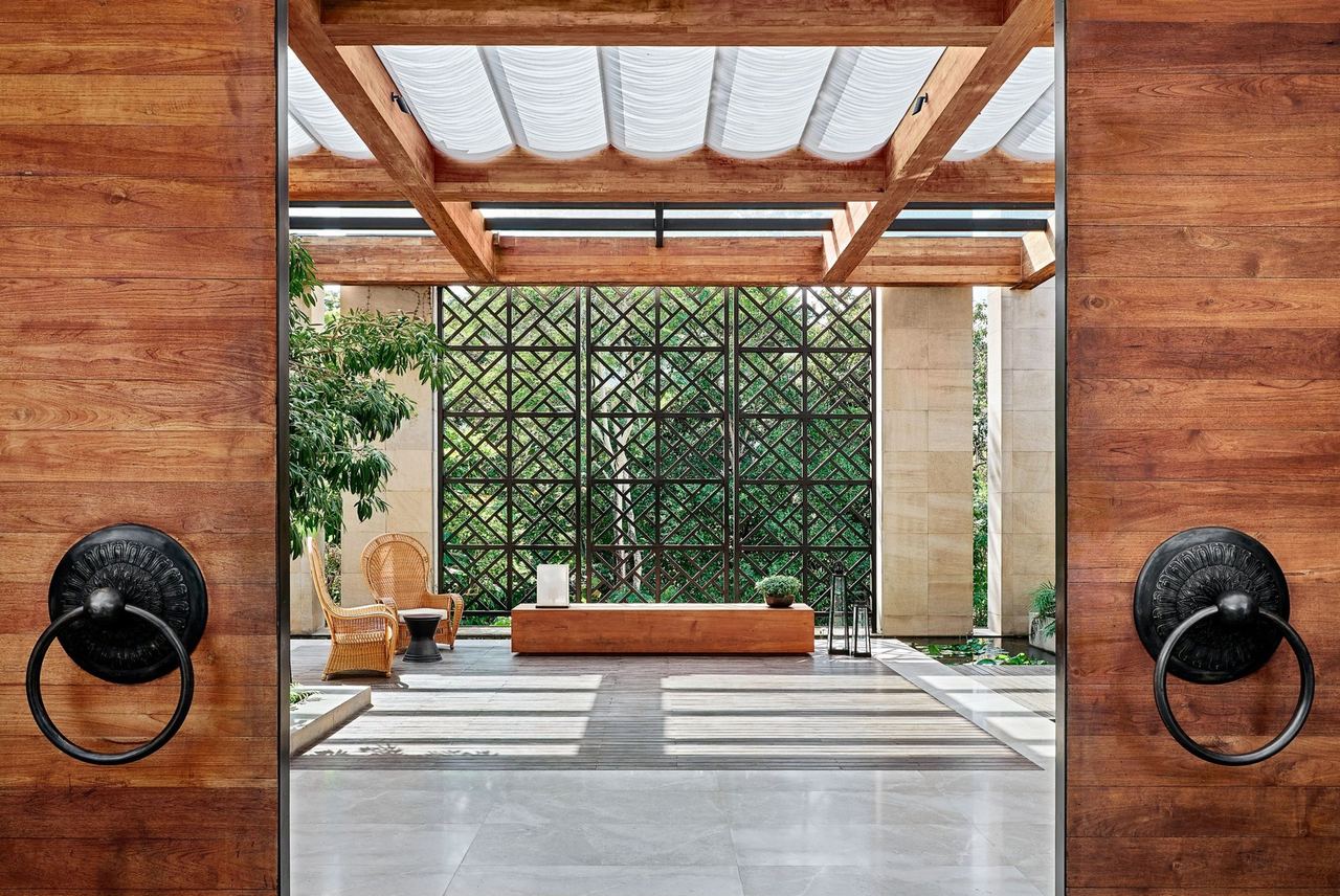 Through the teak doors into the open-air lobby pavilion at Rosewood Phuket